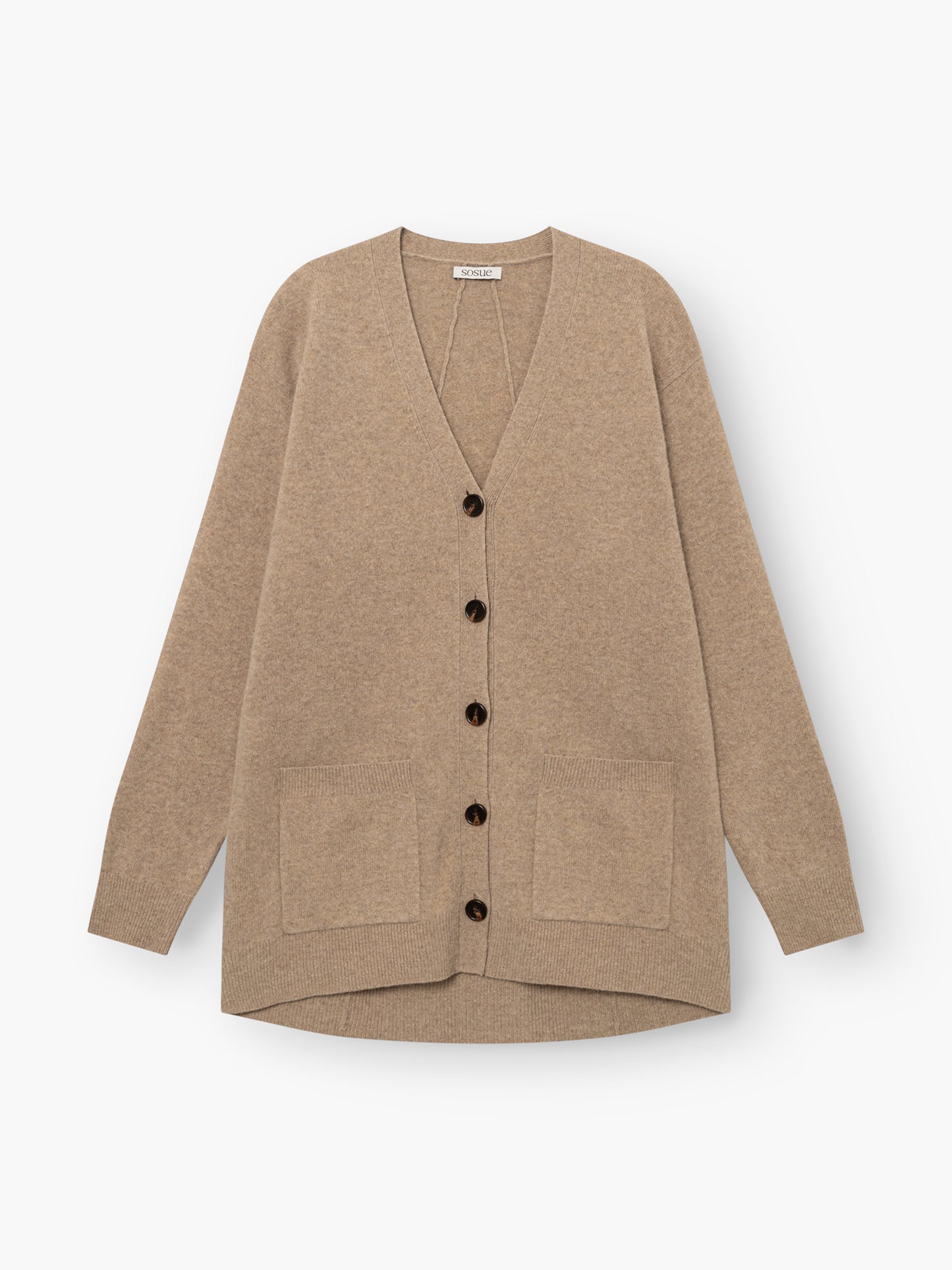 Strickjacke „Lucia Beige“ aus extrafeiner Merinowolle mit langen Ärmeln, schwarzen Knöpfen und zwei Vordertaschen, flach auf weißem Hintergrund präsentiert.