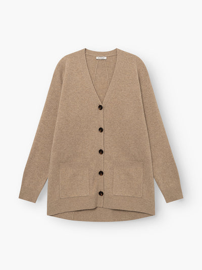 Strickjacke „Lucia Beige“ aus extrafeiner Merinowolle mit langen Ärmeln, schwarzen Knöpfen und zwei Vordertaschen, flach auf weißem Hintergrund präsentiert.
