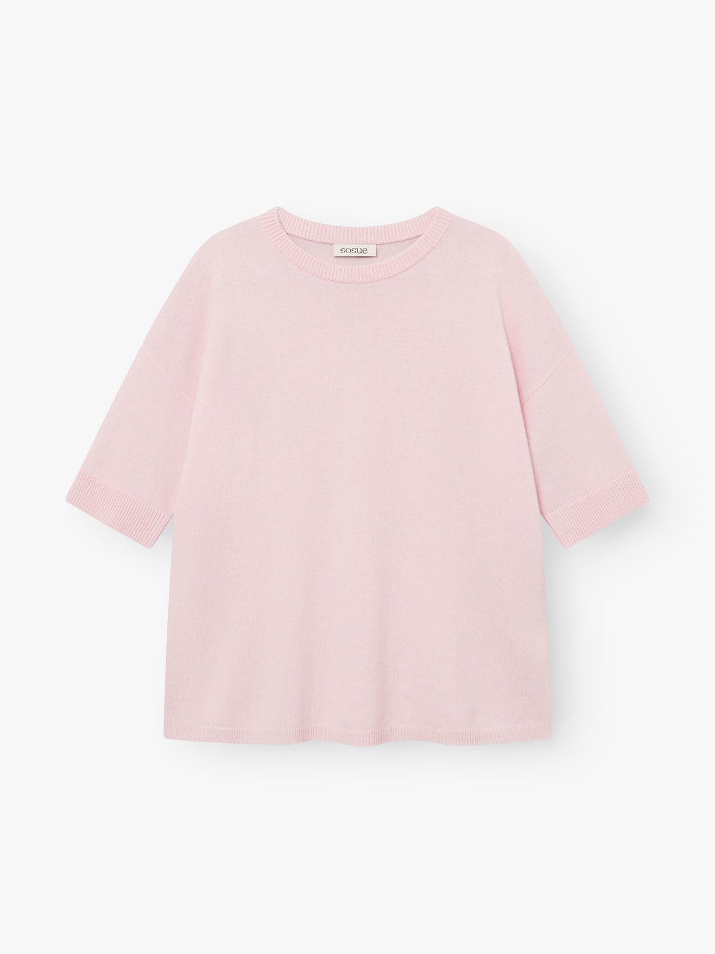 Strick-T-Shirt „Aurora Rose“ in Hellrosa mit kurzen Ärmeln, Rundhalsausschnitt, lockerer Passform und gerippten Säumen an Ärmeln und Saum. Das sichtbare Etikett am Halsausschnitt ist zu sehen, während das Oberteil flach auf einem weißen Hintergrund liegt.