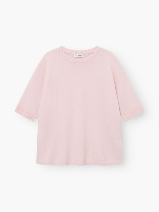 Strick-T-Shirt „Aurora Rose“ in Hellrosa mit kurzen Ärmeln, Rundhalsausschnitt, lockerer Passform und gerippten Säumen an Ärmeln und Saum. Das sichtbare Etikett am Halsausschnitt ist zu sehen, während das Oberteil flach auf einem weißen Hintergrund liegt.