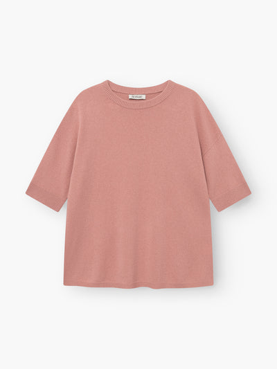 Das Strick-T-Shirt „Aurora Altrosa“ in Blush-Pink liegt flach auf einem weißen Hintergrund. Dieses Damen-Strick-T-Shirt hat kurze Ärmel, einen Rundhalsausschnitt und eine lockere, kastenförmige Passform mit gerippten Säumen an den Ärmelenden, am Saum und am Kragen.