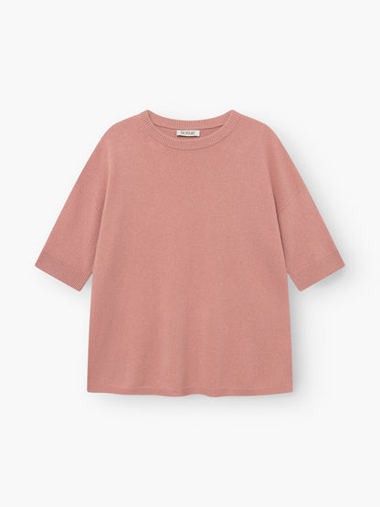 Das Strick-T-Shirt „Aurora Altrosa“ in Blush-Pink liegt flach auf einem weißen Hintergrund. Dieses Damen-Strick-T-Shirt hat kurze Ärmel, einen Rundhalsausschnitt und eine lockere, kastenförmige Passform mit gerippten Säumen an den Ärmelenden, am Saum und am Kragen.
