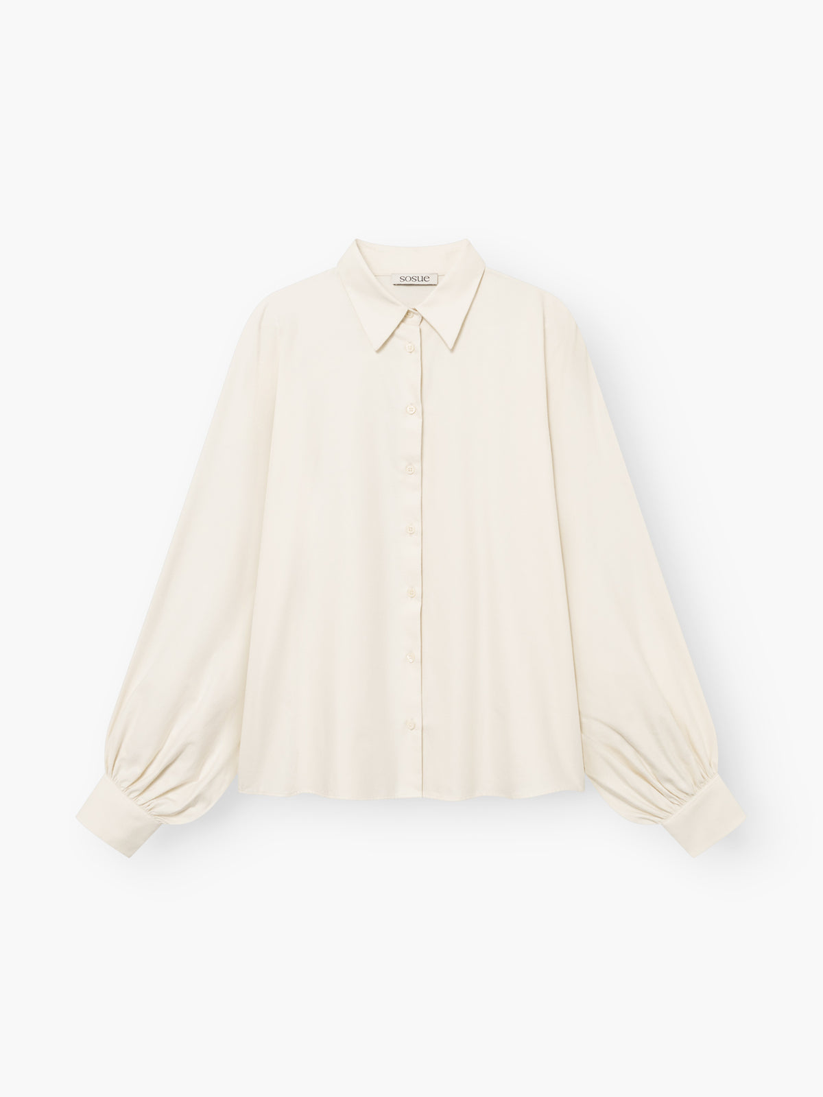 Die Bluse „Antonia Flanell Offwhite“ ist cremefarben, langärmelig und verfügt über einen spitzen Kragen, eine Knopfleiste vorne sowie geraffte Ärmelbündchen. Sie ist aus leichtem Stoff gefertigt und besticht durch eine lockere Passform und eine leicht kastenförmige Silhouette.
