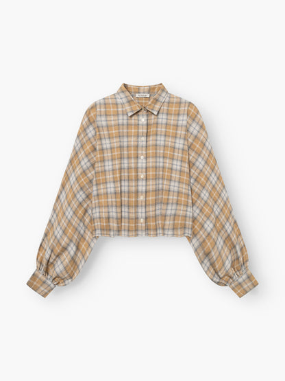 Die Bluse „Antonia Short Flanell Check“ ist eine kurz geschnittene Langarmbluse aus hochwertigem Flanell mit einem Karomuster in Beige, Weiß und Braun, einer Knopfleiste vorne, einem Kragen und breiten, gerafften Manschetten, die für einen stilvollen Look sorgen.