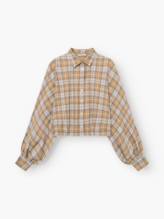 Die Bluse „Antonia Short Flanell Check“ ist eine kurz geschnittene Langarmbluse aus hochwertigem Flanell mit einem Karomuster in Beige, Weiß und Braun, einer Knopfleiste vorne, einem Kragen und breiten, gerafften Manschetten, die für einen stilvollen Look sorgen.