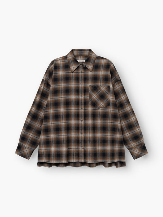 Die Blouse Boxy Long ist ein langärmeliges Flanellhemd mit Knopfleiste in Braun, Schwarz und Beige im Karomuster, mit einer einzelnen Brusttasche und klassischem Kragen, abgebildet vor weißem Hintergrund.
