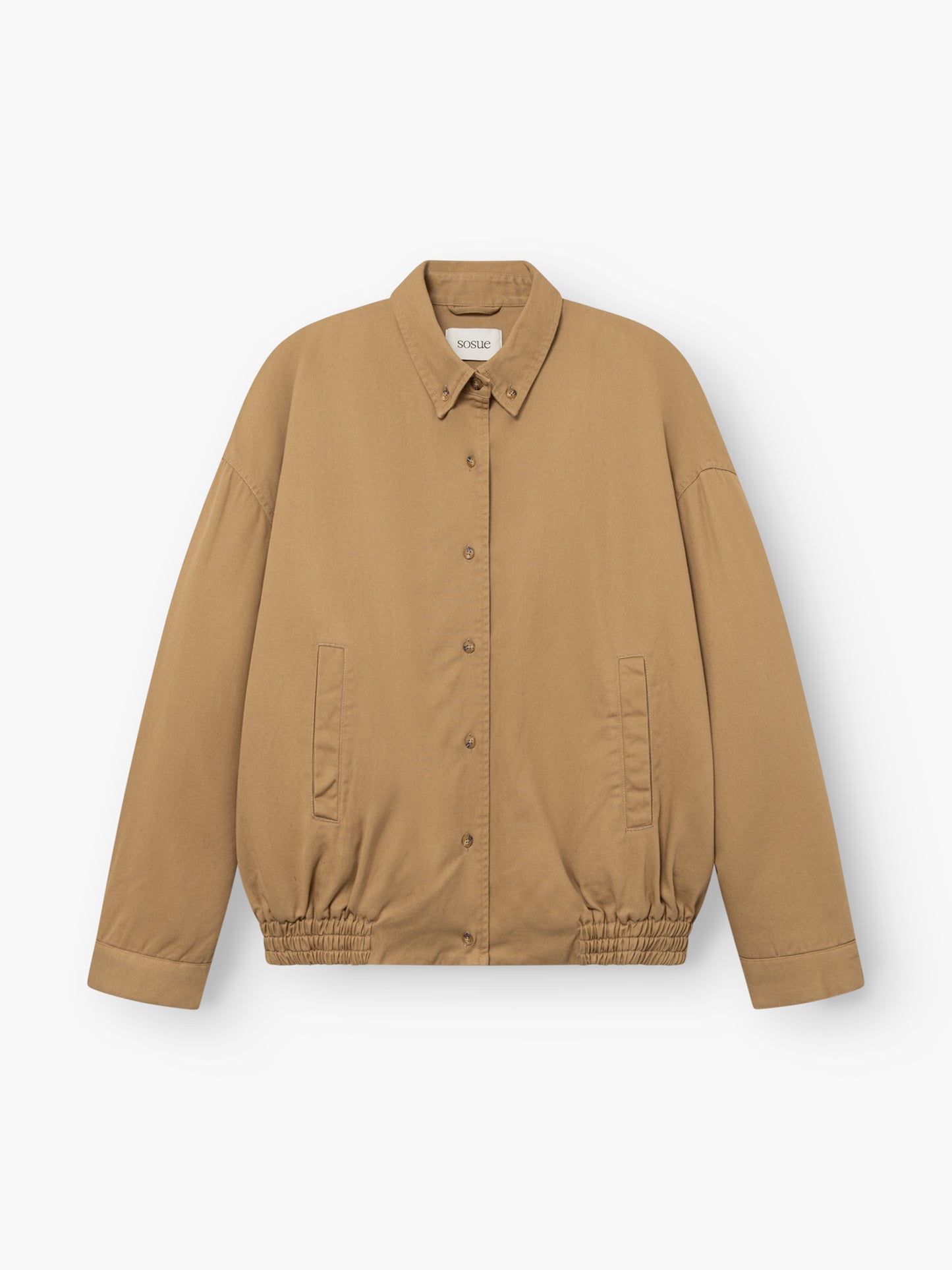 Beigefarbene Bomber-Shorts mit Knopfleiste, Kragen, elastischem Saum und zwei Vordertaschen, abgebildet vor weißem Hintergrund.