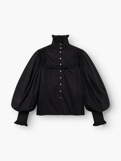 Die Bluse „Victoria“ ist eine schwarze Bluse mit hohem Rüschenkragen, langen Puffärmeln, Rüschendetails, Manschetten und einer Knopfleiste – für einen Hauch viktorianischer Eleganz.