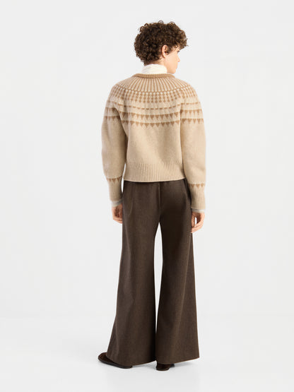 Eine Person mit kurzen Locken und einer braunen Hose mit weitem Bein steht mit dem Rücken zur Kamera vor einem schlichten weißen Hintergrund und trägt die „Norweger Jacket Vol. 3“.