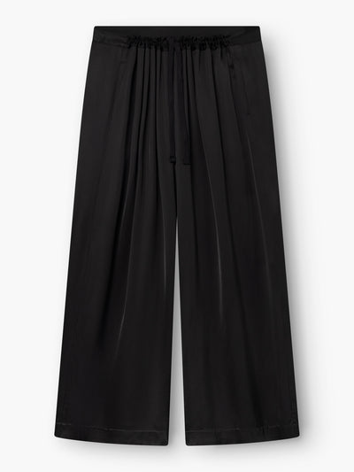 Die schwarze Oversize-Hose besticht durch einen leichten, glänzenden Stoff und einen bequemen, elastischen Bund mit Kordelzug. Diese schwarze Hose hat ein lockeres, fließendes, weit geschnittenes Bein und ist im Taillenbereich mit Falten verziert, die für einen zusätzlichen stilvollen Akzent sorgen.