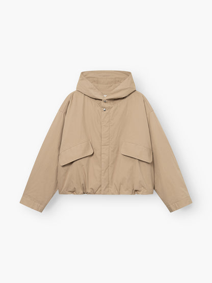 Jacke „Savanna“ in Beige, mit Kapuze, Druckknöpfen, zwei großen Pattentaschen vorne und langen Ärmeln, abgebildet auf weißem Hintergrund.