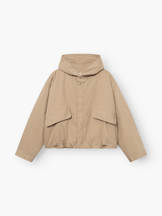 Jacke „Savanna“ in Beige, mit Kapuze, Druckknöpfen, zwei großen Pattentaschen vorne und langen Ärmeln, abgebildet auf weißem Hintergrund.
