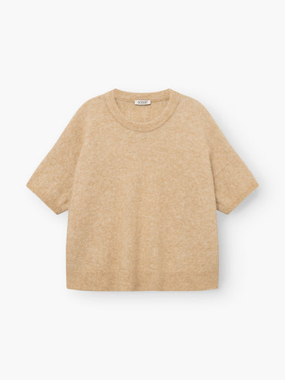 Bear T-Shirt Camel – beiger Kurzarm-Strickpullover mit Rundhalsausschnitt, lockerer Passform und leicht überschnittenen Schultern, flach auf einem weißen Hintergrund liegend. Dieses luxuriöse Basic erinnert an einen eleganten Alpaka-Damenpullover und ist vom Tragekomfort eines T-Shirts aus Alpaka-Merino inspiriert.