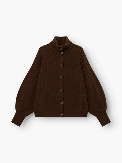 Strickjacke „Bomber Braun“ – eine dunkelbraune, gerippte Strickjacke mit langen Ballonärmeln, hohem Kragen, Knopfleiste vorne und zwei Vordertaschen, abgebildet auf weißem Hintergrund.