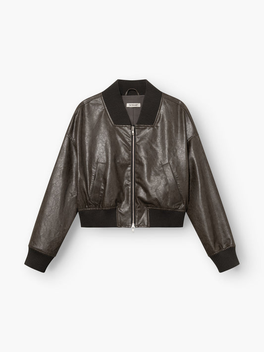 Die vegane Lederjacke „Bomber“ in Schwarz verfügt über einen Reißverschluss vorne sowie gerippte Kragen-, Ärmelbündchen und einen gerippten Saum und wird vor einem weißen Hintergrund präsentiert.