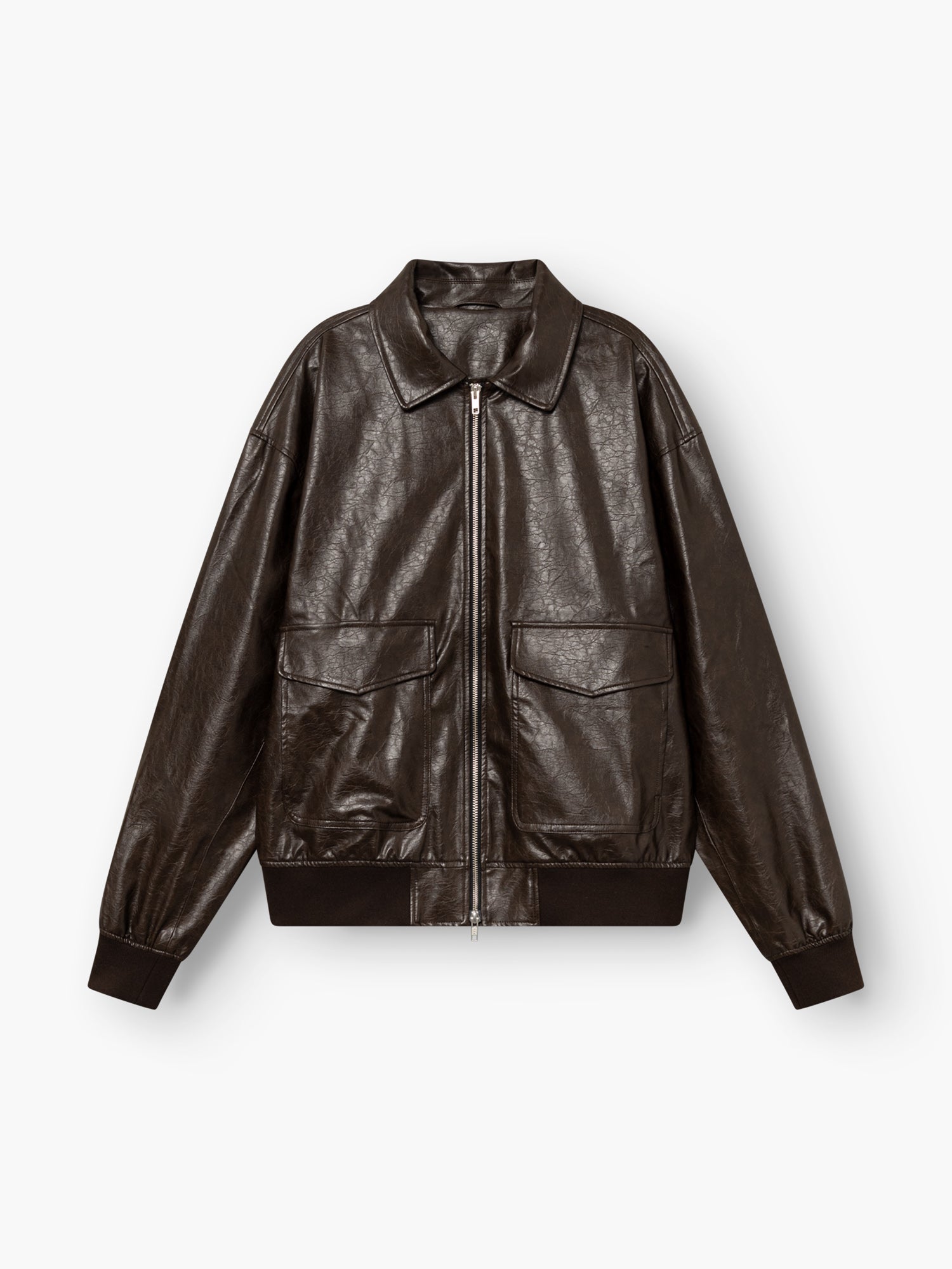Eine Oversize-Jacke aus veganem Leder in Dunkelbraun mit einem Reißverschluss vorne, zwei großen Pattentaschen, einem klassischen Kragen sowie gerippten Bündchen und Saum, abgebildet auf weißem Hintergrund.