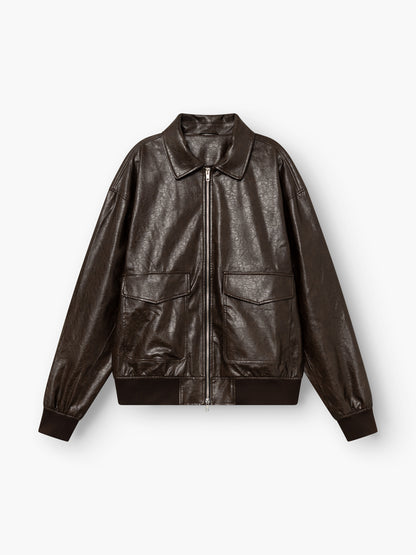 Eine Oversize-Jacke aus veganem Leder in Dunkelbraun mit einem Reißverschluss vorne, zwei großen Pattentaschen, einem klassischen Kragen sowie gerippten Bündchen und Saum, abgebildet auf weißem Hintergrund.