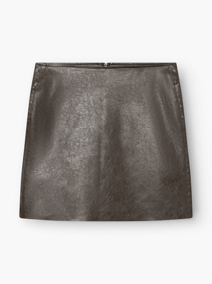 Der „Mini Skirt 70’s“ ist ein dunkelbrauner Minirock aus Kunstleder mit einer dezenten Knitteroptik, geradem Schnitt und einem sichtbaren Reißverschluss am Rücken, fotografiert vor weißem Hintergrund.