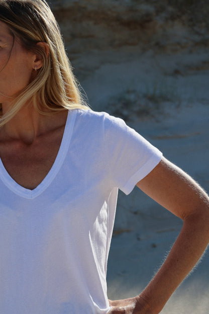 Eine Frau trägt das T-Shirt V-Neck weiß, hergestellt aus 100% Baumwolle.