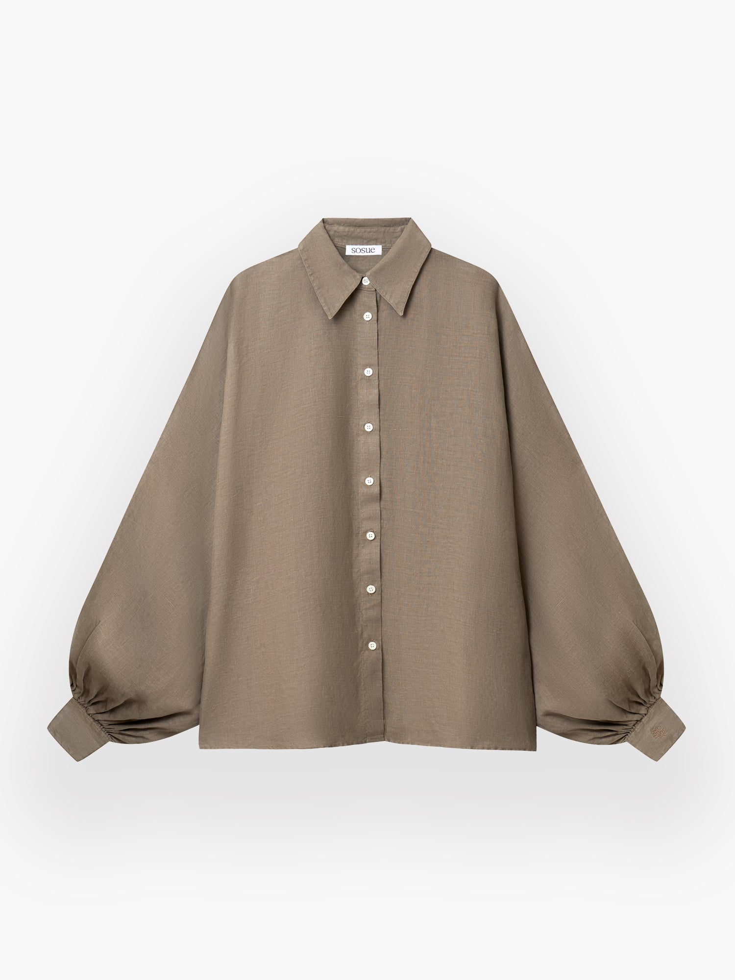 Das Antonia Linen Soft Brown ist ein locker sitzendes, langärmeliges taupefarbenes Hemd aus weichem Leinen mit spitzem Kragen, weißen Knöpfen auf der Vorderseite und weiten, an den Manschetten gerafften Ballonärmeln auf weißem Grund.