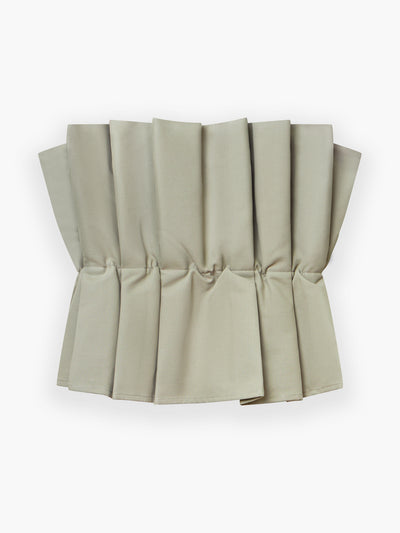 Der Stoff des Pleat Top Olive ist akkordeonartig in saubere, gleichmäßig verteilte Falten gefaltet, die vor einem weißen Hintergrund einen skulpturalen und strukturierten Look erzeugen.
