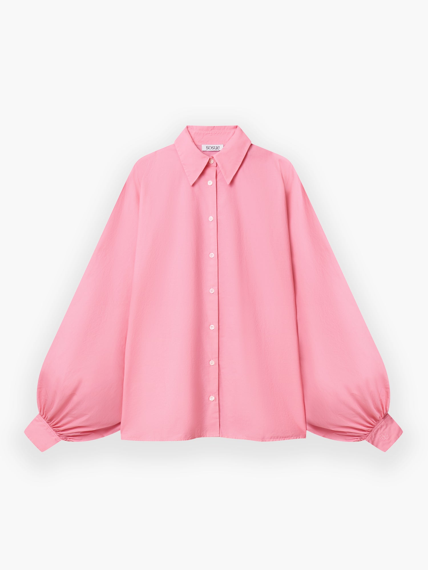 Das Hemd Antonia Cotton Pink hat einen Kragen zum Hochknöpfen, voluminöse geraffte Ärmel, weiße Knöpfe vorne und eine lockere, fließende Passform aus rosa Baumwolle.