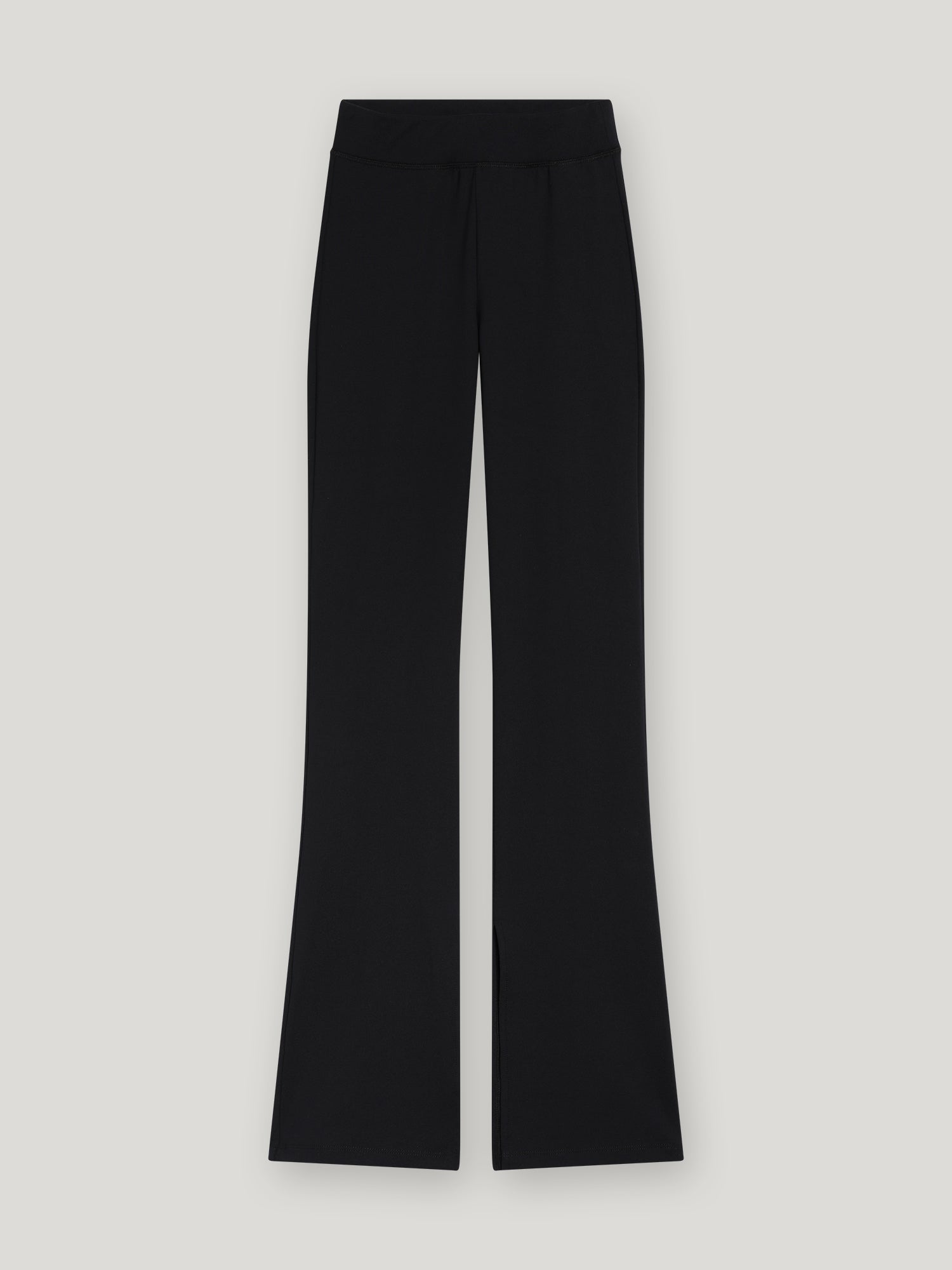 Leggings mit Schlitzen - 80% Recycled in Schwarz, mit hoher Taille, weitem Bein und dezenten Schlitzen am vorderen Saum, hergestellt aus recyceltem Polyester und flach auf hellgrauem Hintergrund.