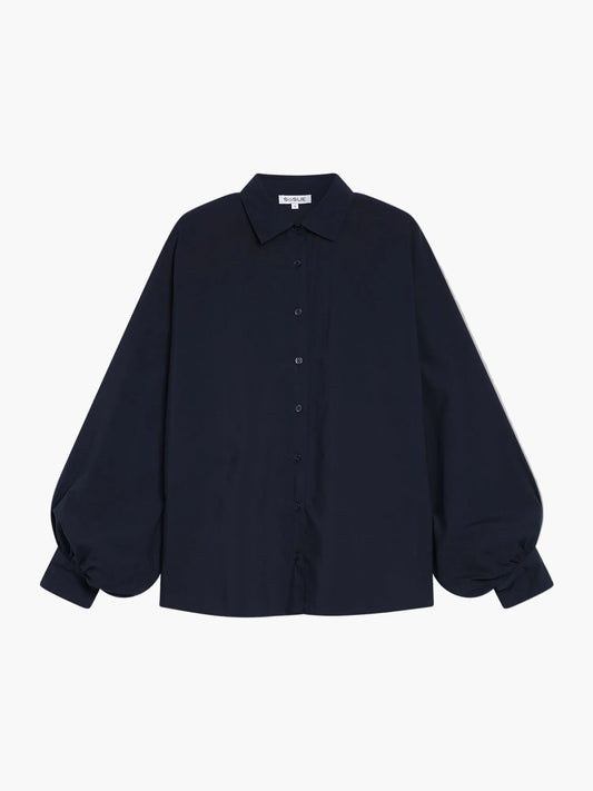 Die Bluse Antonia Slim Dark Blue ist eine langärmelige, dunkelblaue Bluse mit Kragen und gerafften Manschetten, die auf einem schlichten weißen Hintergrund abgebildet ist.
