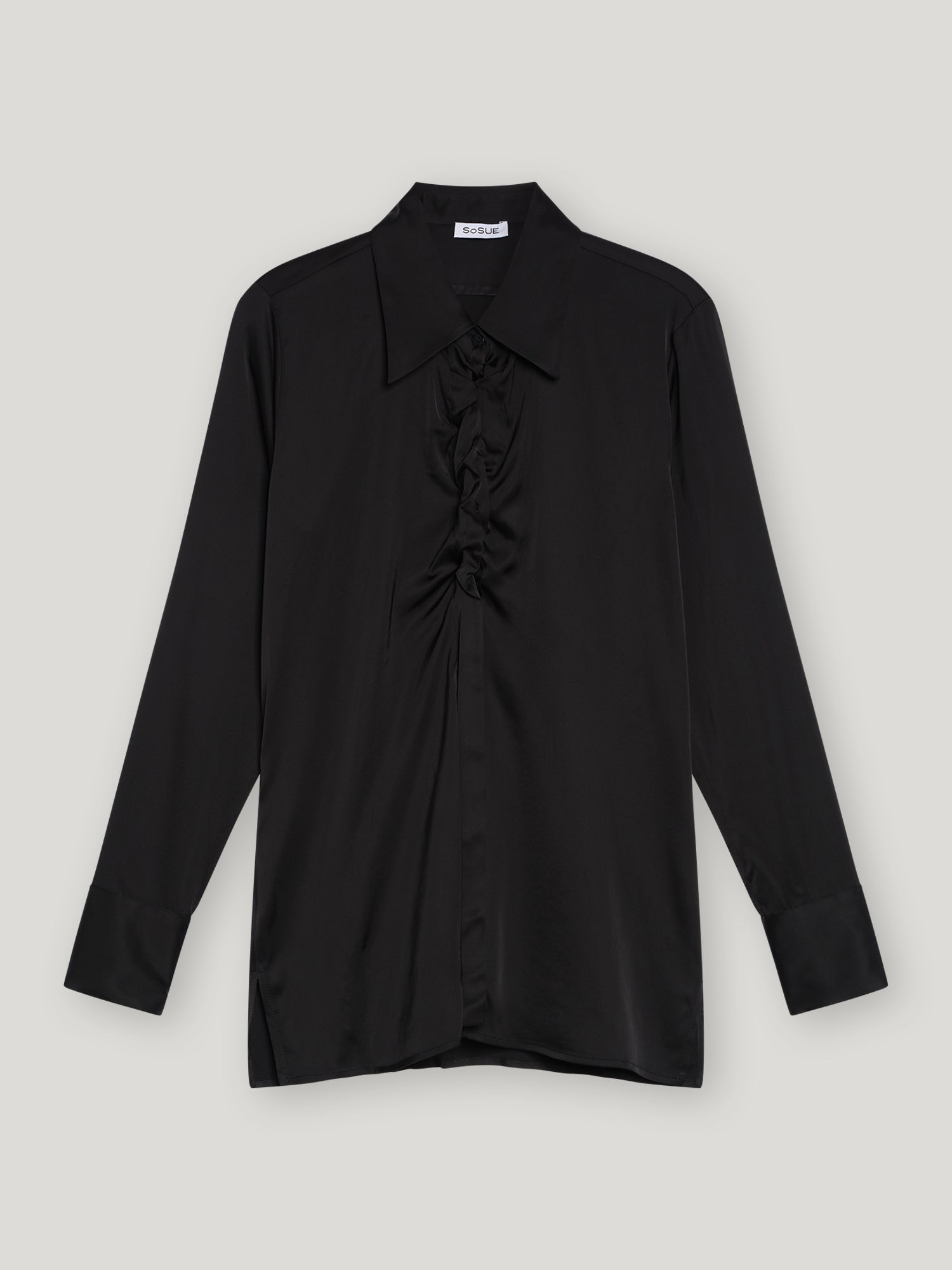 Die Bluse Ella Shiny Black ist eine schwarze Satinbluse mit klassischem Kragen, gerafften Details an der Vorderseite und tailliertem Schnitt. Sie ist flach auf einem hellgrauen Hintergrund ausgelegt.