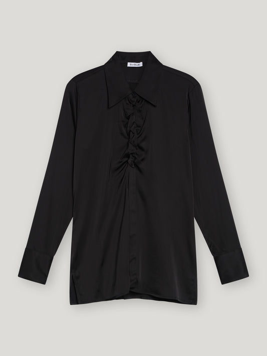 Die Bluse Ella Shiny Black ist eine schwarze Satinbluse mit klassischem Kragen, gerafften Details an der Vorderseite und tailliertem Schnitt. Sie ist flach auf einem hellgrauen Hintergrund ausgelegt.