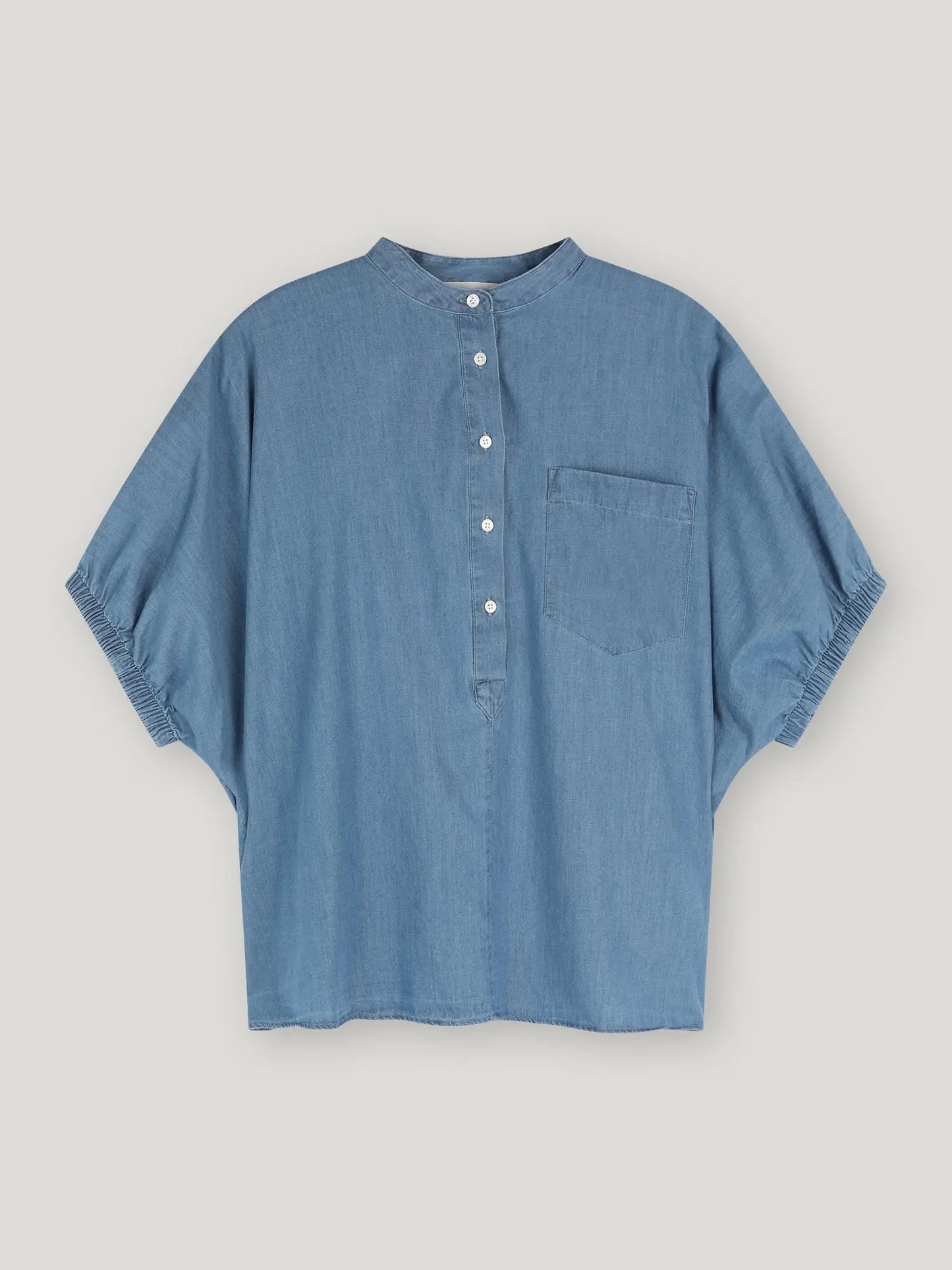 Die Bluse Cowboy Button Denim hat ein blaues Denim-Design mit einer Tasche, perfekt für legere Tage.