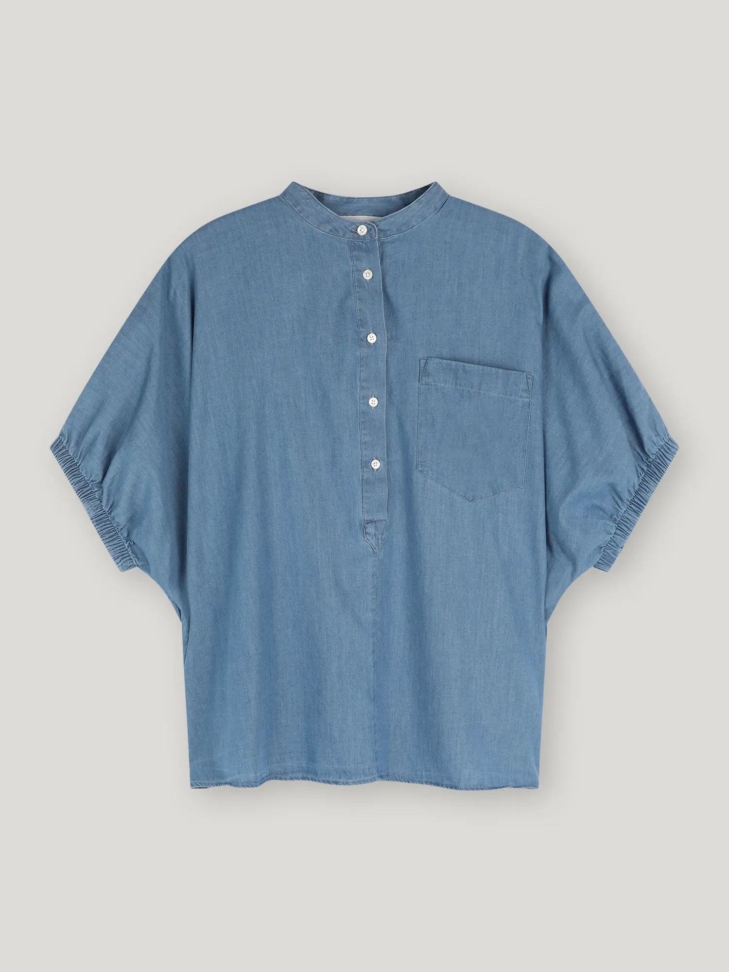 Die Bluse Cowboy Button Denim hat ein blaues Denim-Design mit einer Tasche, perfekt für legere Tage.