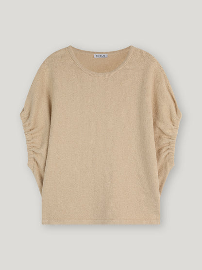 Top Cowboy Knit Beige Damenstrickpullover mit Rundhalsausschnitt und Raffungen an den Seiten der Ärmel, präsentiert vor weißem Hintergrund.