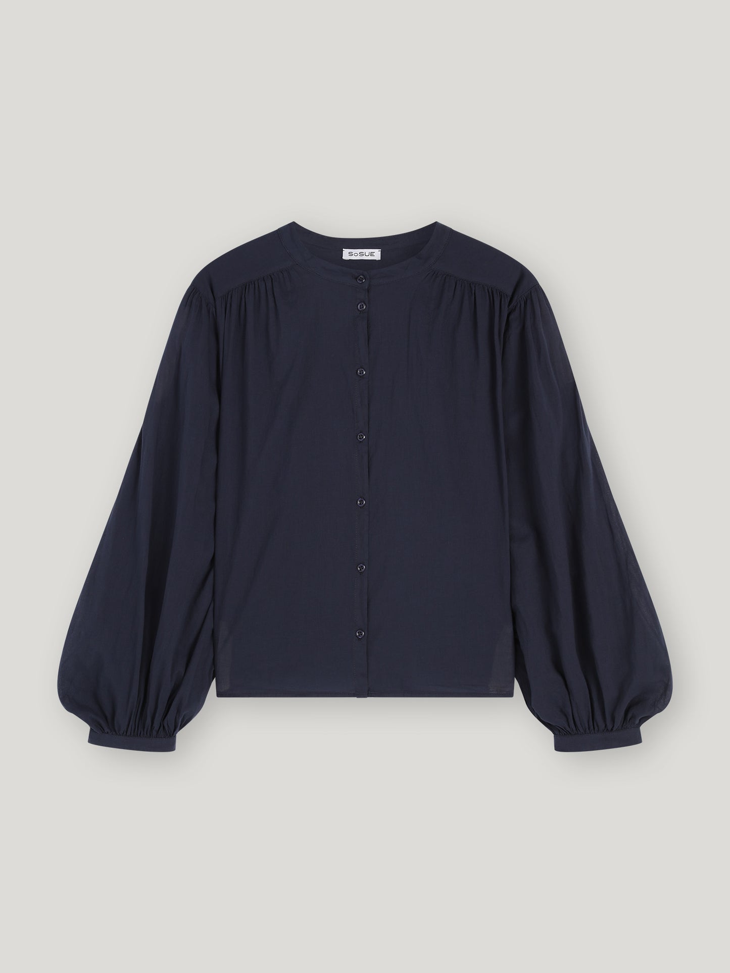 Die Bluse Bella Navy hat einen Rundhalsausschnitt, eine geknöpfte Vorderseite und voluminöse Ballonärmel mit gerafften Manschetten - eine marineblaue Bluse in Übergröße, die perfekt für jede stilvolle Garderobe ist.