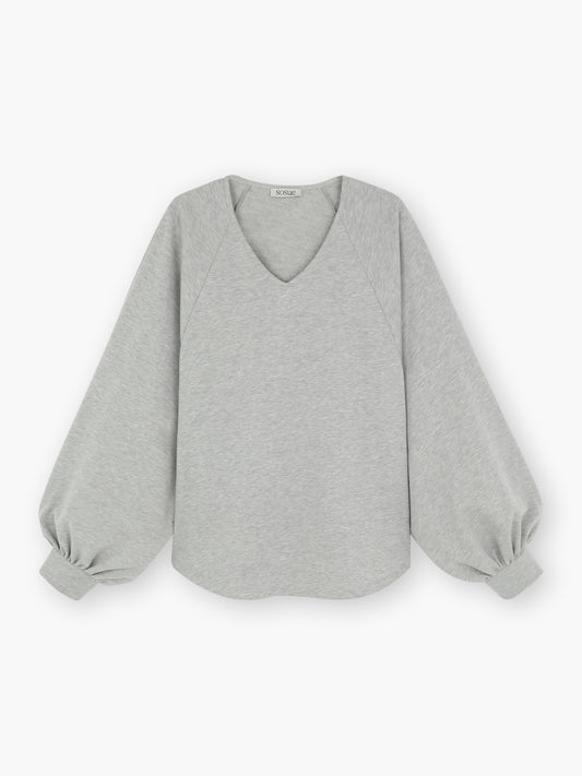 Das Sweatshirt Antonia Grey Mélange hat einen hellgrauen Farbton, einen V-Ausschnitt und lockere Ballonärmel, die an den Handgelenken gerafft sind, in einem einfachen Oversize-Schnitt. Das schlichte Design wird flach auf weißem Grund präsentiert.