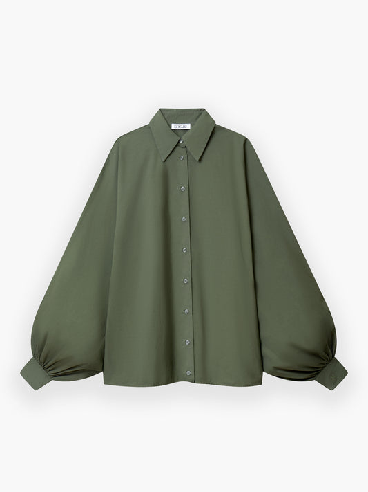 Die Antonia Cotton Olive ist eine locker sitzende, langärmelige Bluse aus olivgrüner Baumwolle mit spitzem Kragen und Puffärmeln, die an den Manschetten geschlossen werden. Sie ist flach auf weißem Grund abgebildet.