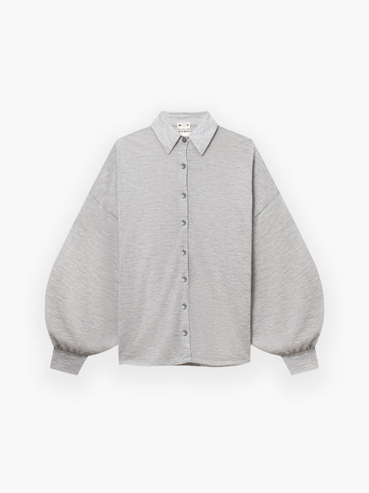 Die Bluse Antonia Cashmere Light Grey One Size von Ella Silla x SOSUE überzeugt mit spitzem Kragen und voluminösen Ärmeln - luxuriöse Eleganz in Kaschmir, stilvoll inszeniert auf schlichtem Weiß.