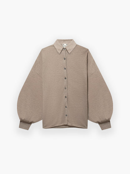 Das Bluse Antonia Cashmere Taupe One Size von Ella Silla x SOSUE ist ein beigefarbenes Button-up-Hemd mit spitzem Kragen, langen, voluminösen Ärmeln, geknöpften Manschetten und lockerer Passform aus 100% Kaschmir auf weißem Grund.