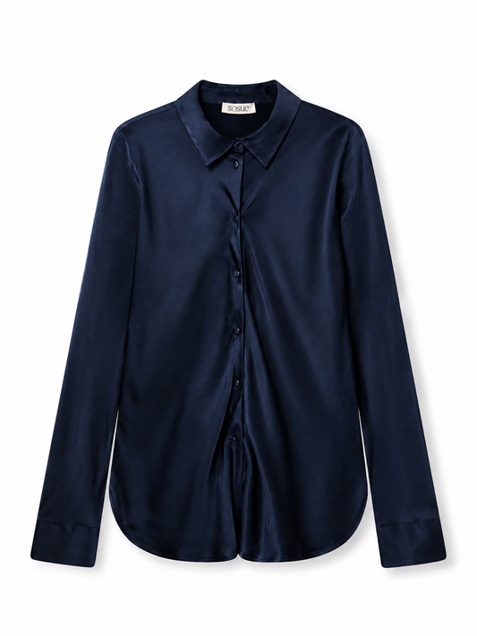 Die langärmelige Bluse „Kaia Dunkelblau“ aus dunkelblauer Seide mit Kragen und Knopfleiste vorne ist eine wunderschön fließende Bluse, die in Portugal hergestellt wurde und hier vor weißem Hintergrund präsentiert wird.