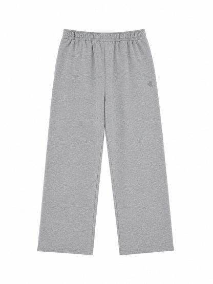 Graue Jogginghose in Oversize-Passform mit elastischem Bund und weitem Bein, flach auf einem weißen Hintergrund liegend. Hergestellt in Portugal.
