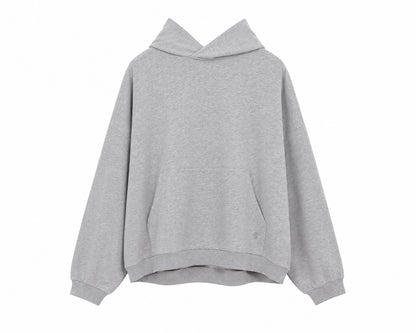 Der „Grauer Oversized Hoodie“, der in Portugal aus weichem Fleece hergestellt wird, ist ein einfarbiger, hellgrauer Hoodie mit langen Ärmeln, einer Kängurutasche vorne sowie gerippten Bündchen und Saum, dargestellt auf weißem Hintergrund.