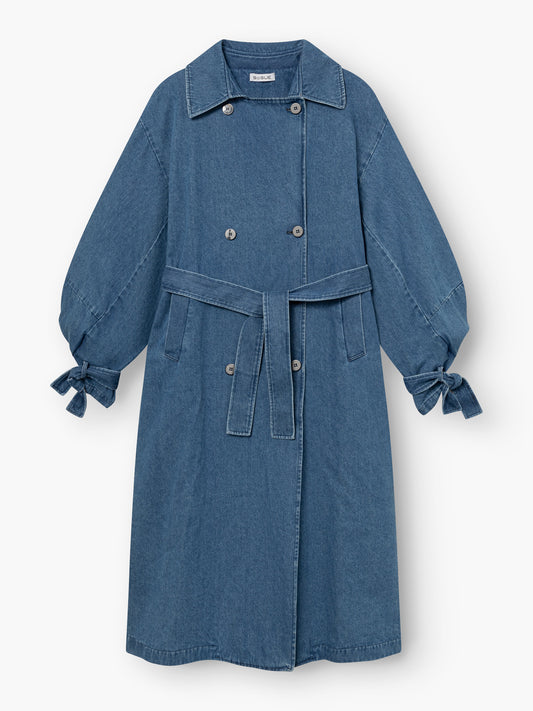 Der Antonia Denim Trench ist ein langer blauer Mantel mit Taillengürtel, doppelreihiger Knopfleiste, klassischem Kragen, sichtbaren Nahtdetails, an den Handgelenken gerafften Ärmeln mit geknüpften Manschetten und einfacher Einheitsgröße.