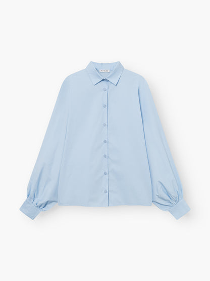Die Bluse Antonia Slim Light Blue ist eine langärmelige Button-up-Bluse mit spitzem Kragen und lockeren, weiten Ärmeln, die auf einem einfarbig weißen Hintergrund gezeigt wird.