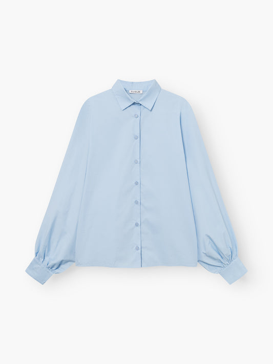 Die Bluse Antonia Slim Light Blue ist eine langärmelige Button-up-Bluse mit spitzem Kragen und lockeren, weiten Ärmeln, die auf einem einfarbig weißen Hintergrund gezeigt wird.