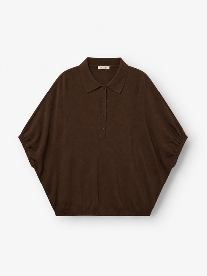 Ein brauner „Cowboy Polo“-Strickpullover mit kurzen Ärmeln, lockerer Passform, Kragen und Knöpfen vorne ist aus einer feinen Merinowolle-Kaschmir-Mischung gefertigt und wird vor einem weißen Hintergrund präsentiert.