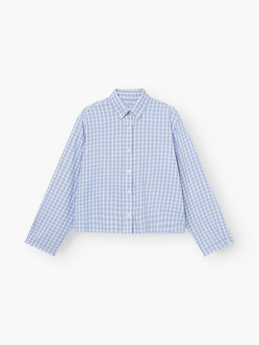 Die Bluse Casual Check in blau-weißem Karo ist ein langärmeliges Hemd mit Kragen und Knopfleiste, das flach auf weißem Hintergrund abgebildet ist.