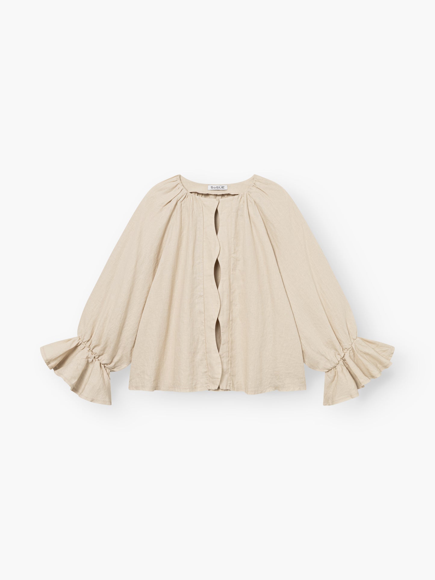 Die Bluse Wave Linen Beige ist ein hellbeiges, langärmeliges Oberteil mit gerüschten Manschetten, einer lockeren Passform, einem Rundhalsausschnitt mit gerafften Schultern und einer gewellten offenen Knopfleiste. Hergestellt aus weichem, leichtem Leinen für einen bequemen Stil.