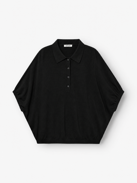 Ein schwarzer Cowboy-Polo-Pullover mit kurzen Ärmeln, lockerer und weiter Passform, Knopfleiste vorne und spitzem Kragen ist flach auf einem weißen Hintergrund abgebildet.