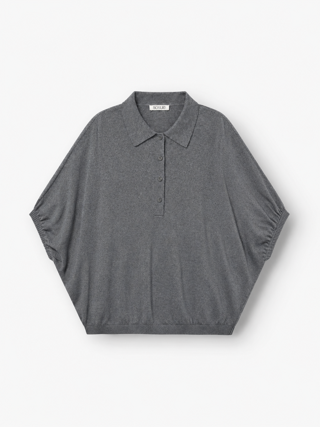 Ein graues Cowboy-Polo aus Feinstrick – kurzärmelig, mit Kragen, drei Knöpfen, lockerer Passform und geripptem Saum – wird flach auf weißem Hintergrund präsentiert. Dieses hochwertige Strick-Polo ist perfekt für alle, die raffinierten Komfort in einem Feinstrickpullover für Herren suchen, und bietet zeitlosen Stil für jeden Anlass.