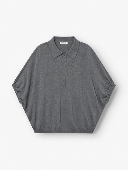 Ein graues Cowboy-Polo aus Feinstrick – kurzärmelig, mit Kragen, drei Knöpfen, lockerer Passform und geripptem Saum – wird flach auf weißem Hintergrund präsentiert. Dieses hochwertige Strick-Polo ist perfekt für alle, die raffinierten Komfort in einem Feinstrickpullover für Herren suchen, und bietet zeitlosen Stil für jeden Anlass.
